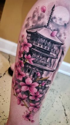 a woman's leg with flowers on it and a building in the background,