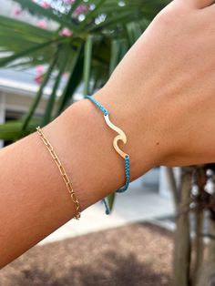 The Pura Vida Hammered Wave Bracelet in Pacific Blue features a beautifully braided string and a brass gold plated wave charm. Designed for a trendy and effortless beachy look, this bracelet adds a touch of elegance and style to any outfit. Handcrafted by artisans, each purchase helps support their local communities. Gold Bracelet With Adjustable Length For Beach, Gold Jewelry With Adjustable Length For Vacation, Casual Gold Braided Bracelet With Adjustable Cord, Casual Gold Resizable Braided Bracelets, Gold Friendship Bracelets With Adjustable Cord For Beach, Gold Braided Bracelets With Adjustable Length For Beach, Gold Adjustable Cord Friendship Bracelets For Beach, Blue Jewelry With Adjustable Cord For Vacation, Gold Sliding Knot Jewelry For Vacation