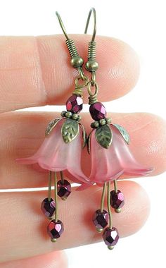 some pretty pink flowers are hanging from earrings