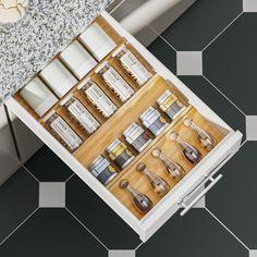 an open drawer with various items on the drawers and in front of it is a tiled floor