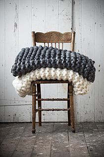 a wooden chair with two knitted cushions on it