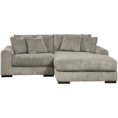 a gray couch with pillows on it and a footstool in the middle, sitting against a white background