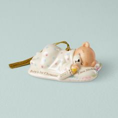 a ceramic ornament shaped like a baby's 1st christmas bear laying down