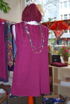 a woman's purple sweater and dress on display