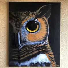 an owl's eye is shown on a black and brown painting hanging on the wall