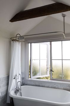 a white bath tub sitting next to a window