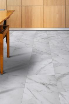 a kitchen with marble flooring and wooden cabinetry in the backround area