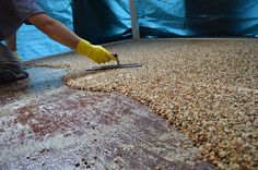 a man in yellow gloves is sanding the floor