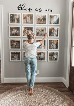 a woman standing in front of a wall with pictures on it