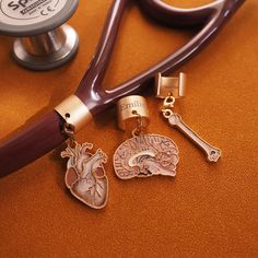 a stethoscope with two charms attached to it next to a pair of scissors