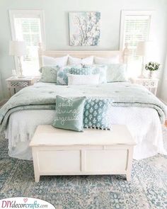 a white bed with blue and green pillows