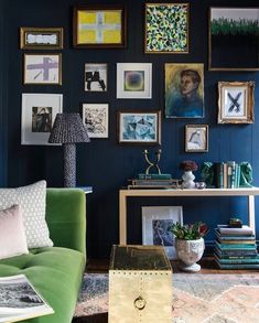 a living room with blue walls and pictures on the wall, including a green couch