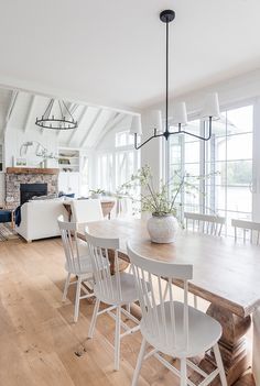 a dining room table with white chairs around it