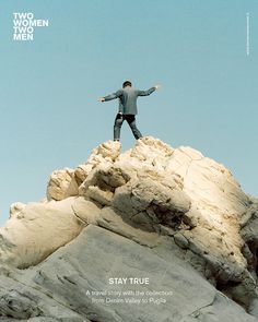 a man standing on top of a rocky mountain with his arms spread out in the air