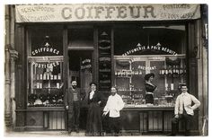 an old black and white photo of people standing in front of a store