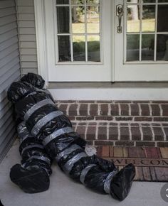 a black bag sitting on the ground in front of a white door with two windows