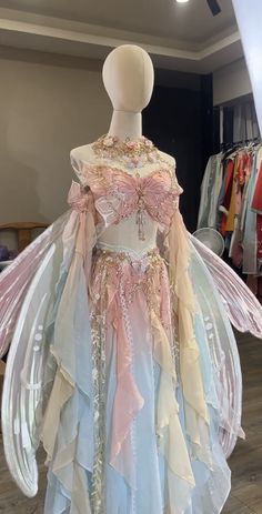 a mannequin dressed in pastel colors with wings on it's head