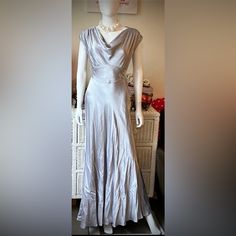 a mannequin wearing a silver dress in a room