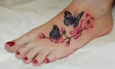 a woman's foot with flowers and butterflies on it