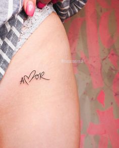 a woman's thigh with the word love written in cursive writing on it