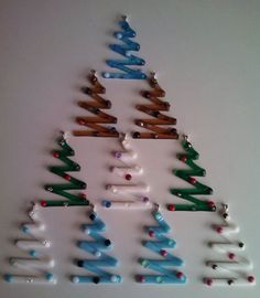 a christmas tree made out of toothbrushes on a white surface with the word merry written below it