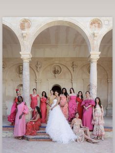 a group of women standing next to each other in front of a building with columns