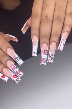 two hands with pink and white manies holding onto each other's nails, one has hearts on it