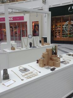 a display in a store filled with lots of necklaces and other jewelry on tables