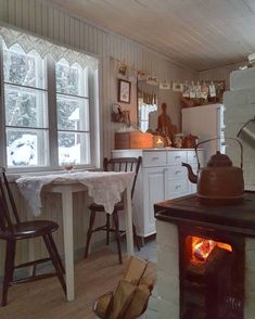 a kitchen with a stove, table and chairs next to an open fire place in the fireplace