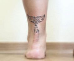 a woman's foot with a small tattoo on the top and bottom part of her leg