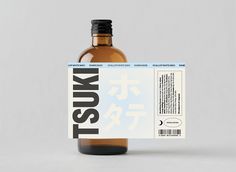 a bottle of liquid sitting on top of a white table next to a label with the word kusui written in it