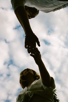 two people reaching up into the air to reach something