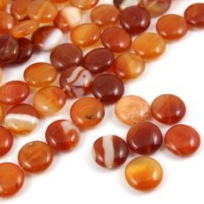 some very pretty orange and brown beads on a white surface