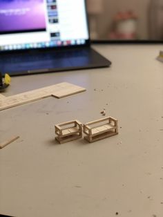 two pieces of wood sitting on top of a table next to a laptop computer screen