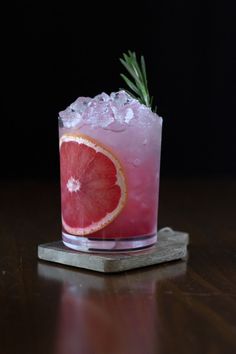 a grapefruit cocktail garnished with rosemary