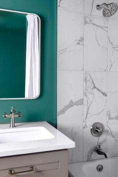 a white sink sitting under a bathroom mirror next to a bath tub and shower head