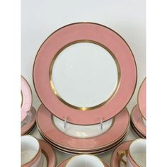 a pink and gold dinner set with matching plates