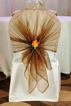 the back of a chair with a flower on it and an orange rose in the center