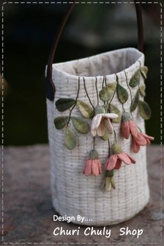 a white basket with flowers hanging from it