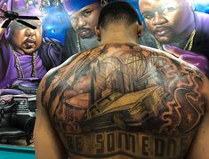 the back of a man's body with tattoos on it and two men behind him