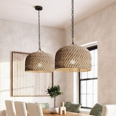 two chandeliers hanging from the ceiling above a dining room table with white chairs