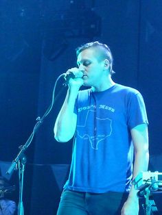 a man standing in front of a microphone on stage