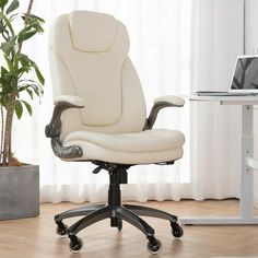 a white office chair sitting on top of a hard wood floor next to a window