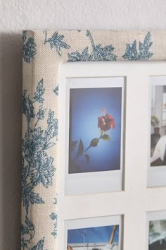 a white frame with blue flowers and pictures on the front is hanging on a wall