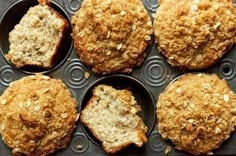 six muffins are sitting in a muffin tin with oats on top