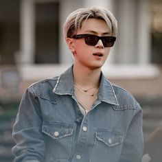 a person wearing sunglasses and a denim shirt