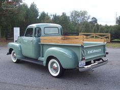 an old pick up truck parked in a parking lot