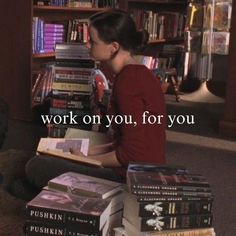 a woman sitting on the floor in front of a book shelf filled with lots of books