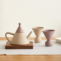 three cups and a teapot on a table