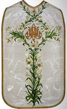 an embroidered cross with flowers and leaves on it